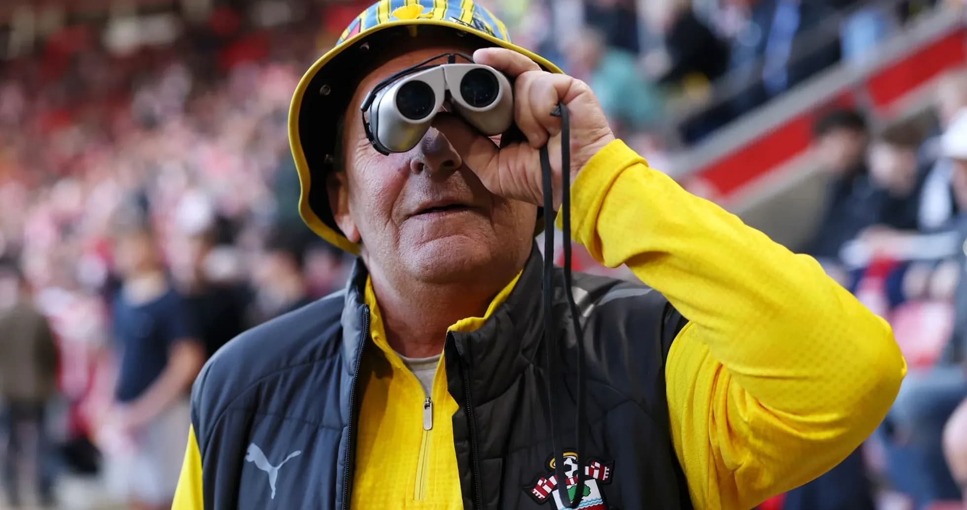 Fan wearing binoculars at a football match Fan wearing binoculars at a football match