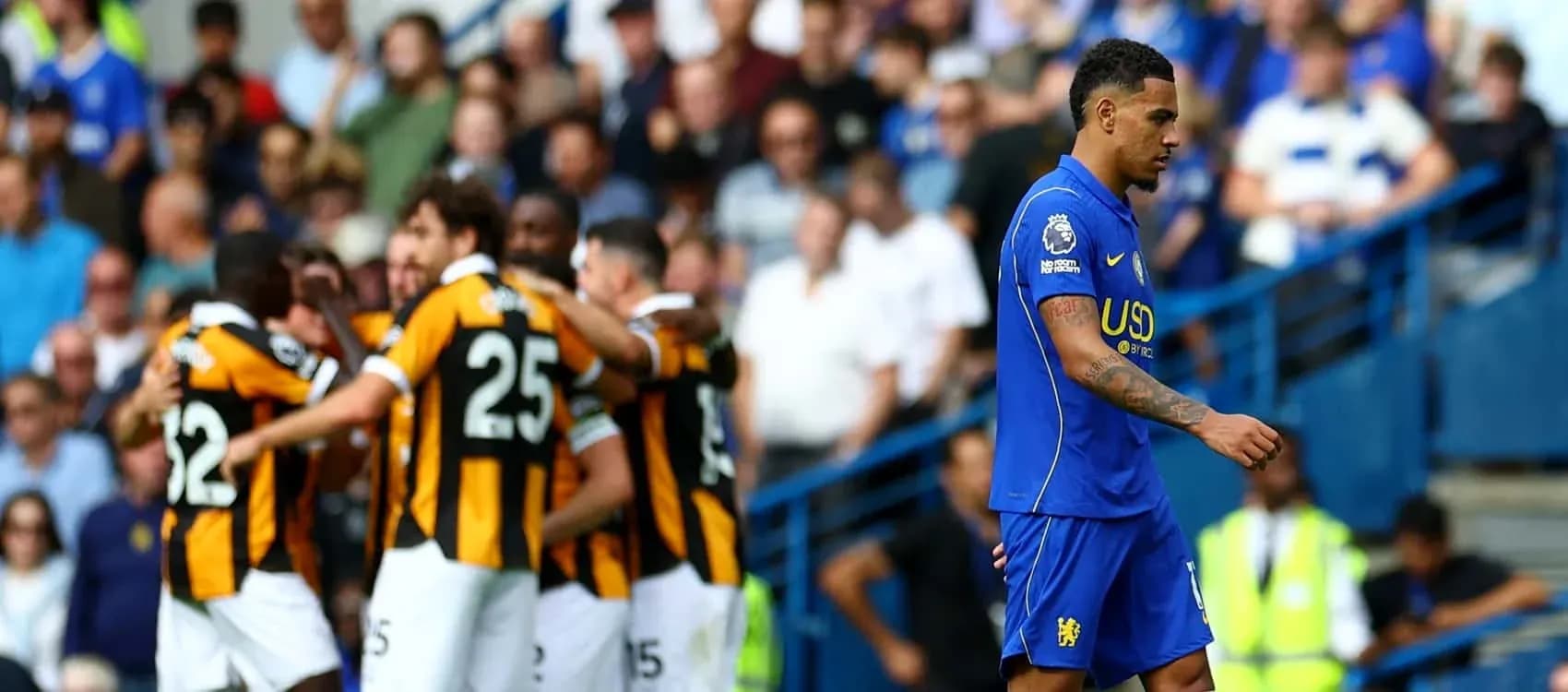 Player walking away as teammates celebrate goal Player walking away as teammates celebrate goal