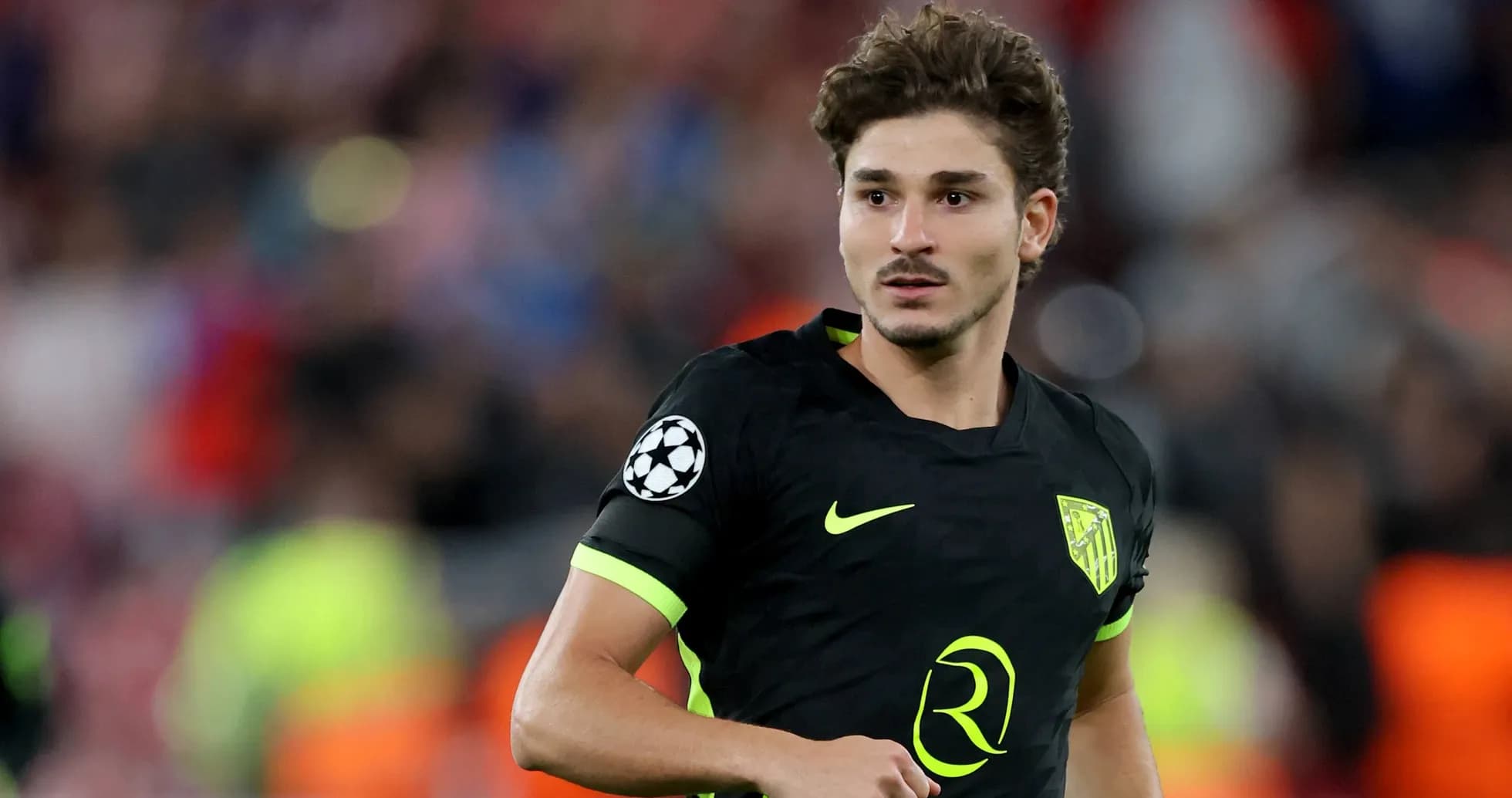 Player in black jersey during UEFA Champions League match Player in black jersey during UEFA Champions League match