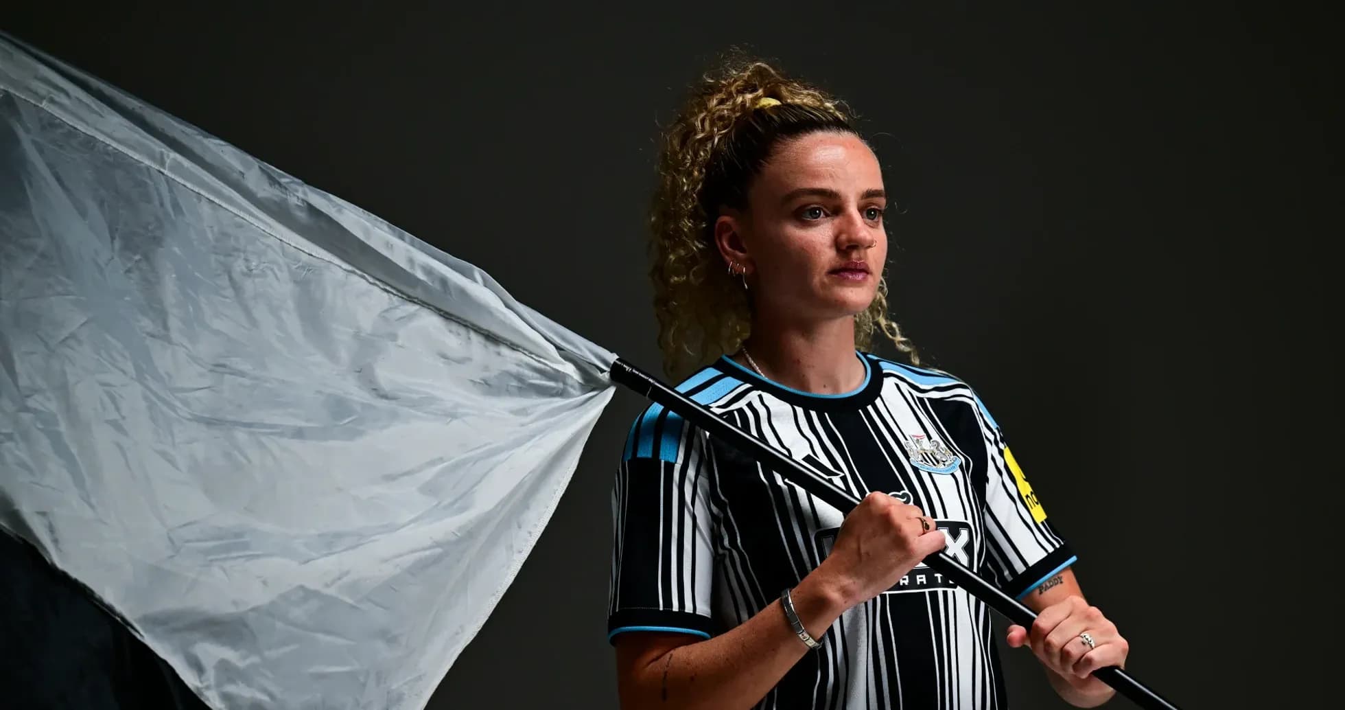Player holding a flag in Newcastle kit Player holding a flag in Newcastle kit