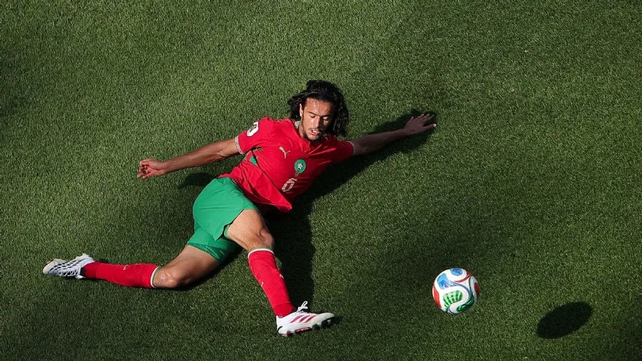 Moroccan player sliding on grass toward soccer ball Moroccan player sliding on grass toward soccer ball