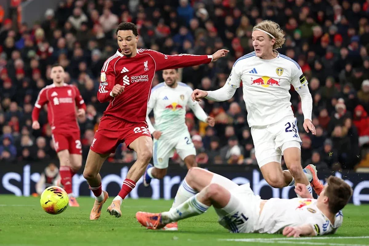Liverpool player dribbling past Leeds defenders on pitch Liverpool player dribbling past Leeds defenders on pitch