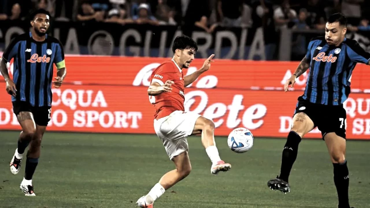 Player kicking ball during match with opponents nearby Player kicking ball during match with opponents nearby