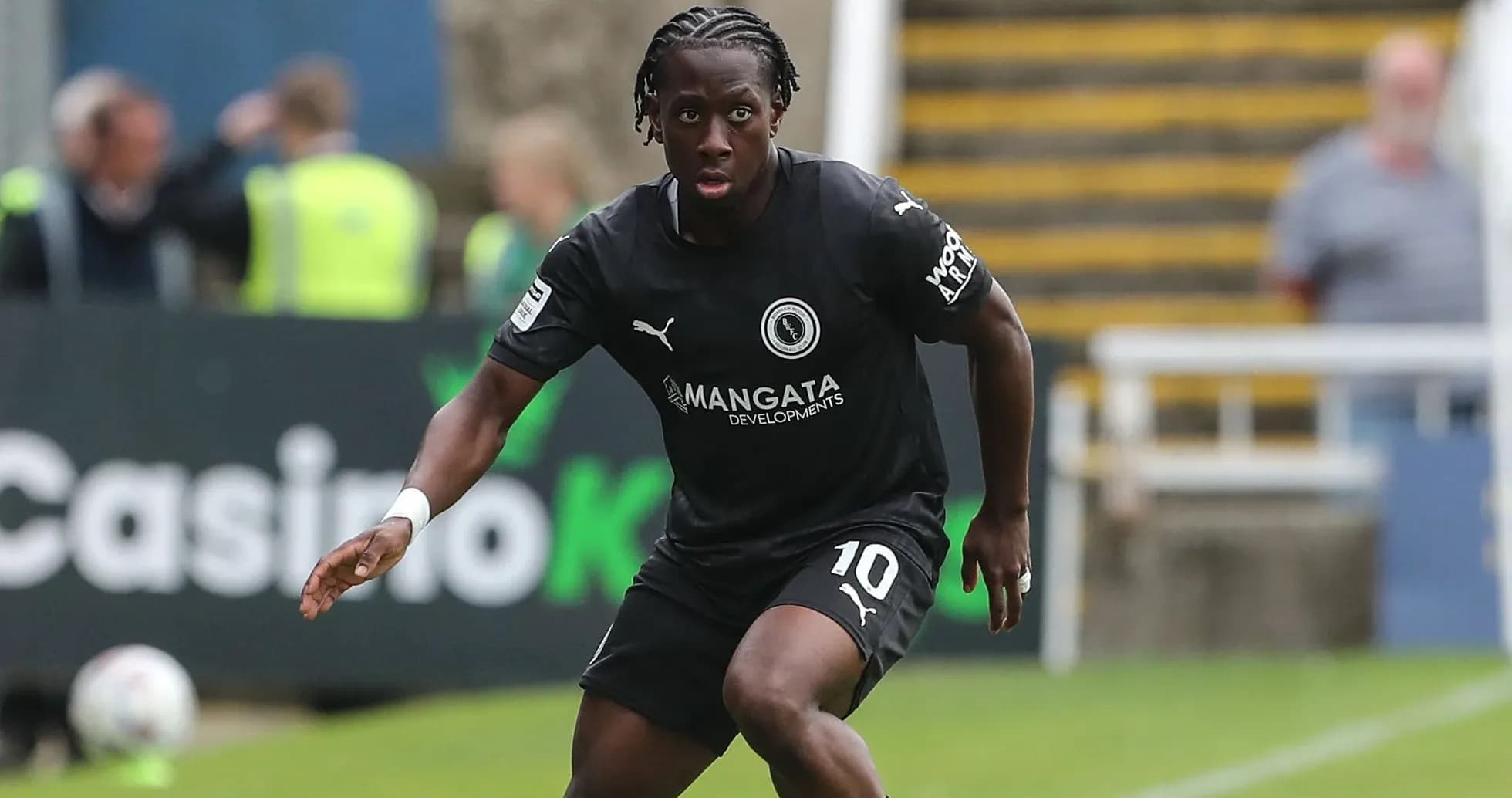 Player in black kit running on the pitch Player in black kit running on the pitch