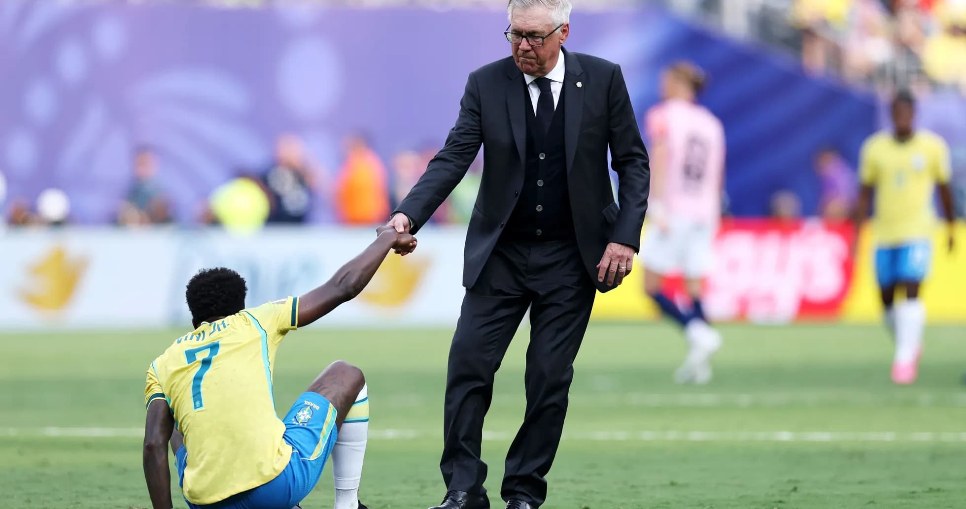 Coach assisting player sitting on the field Coach assisting player sitting on the field