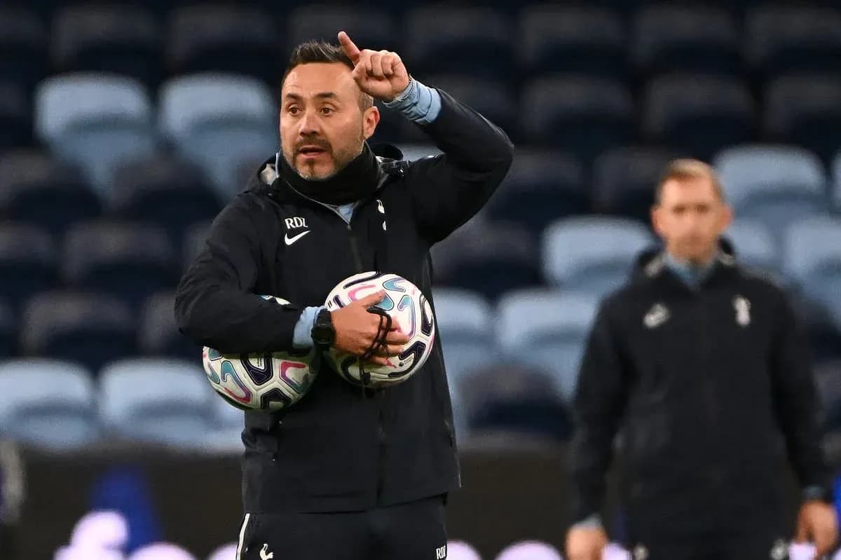 Coach instructing players while holding footballs Coach instructing players while holding footballs