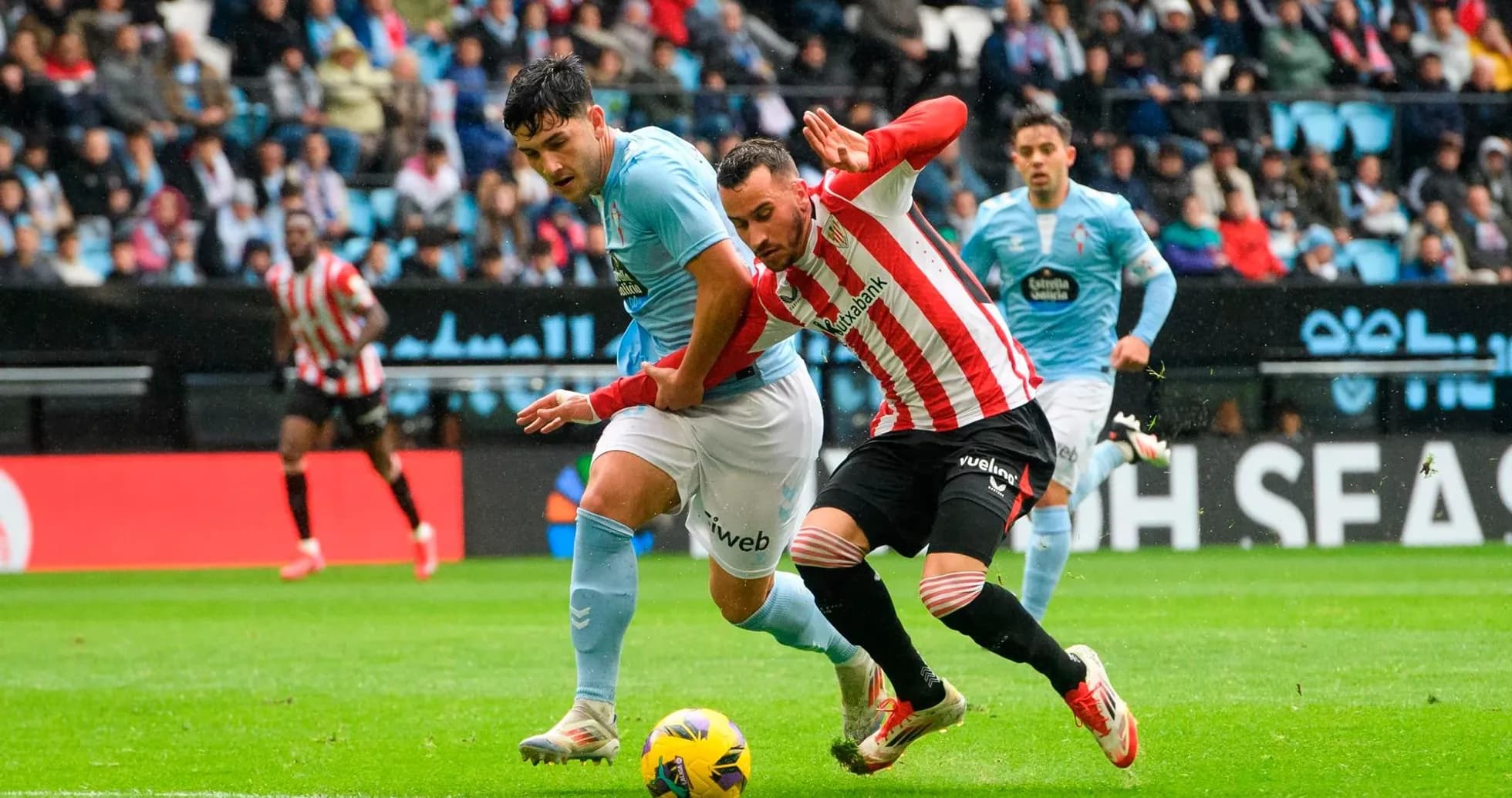 Athletic Club player tackling Celta Vigo opponent Athletic Club player tackling Celta Vigo opponent