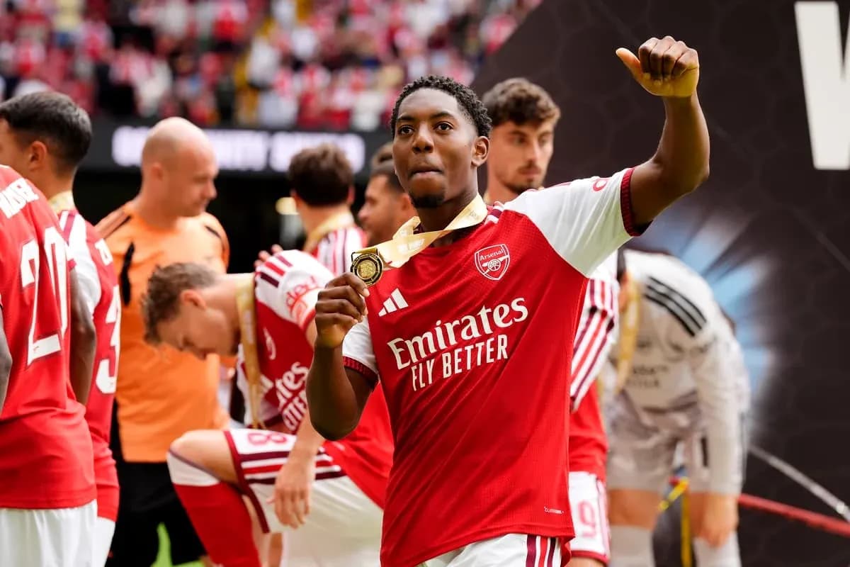 Arsenal player celebrating with medal after match Arsenal player celebrating with medal after match
