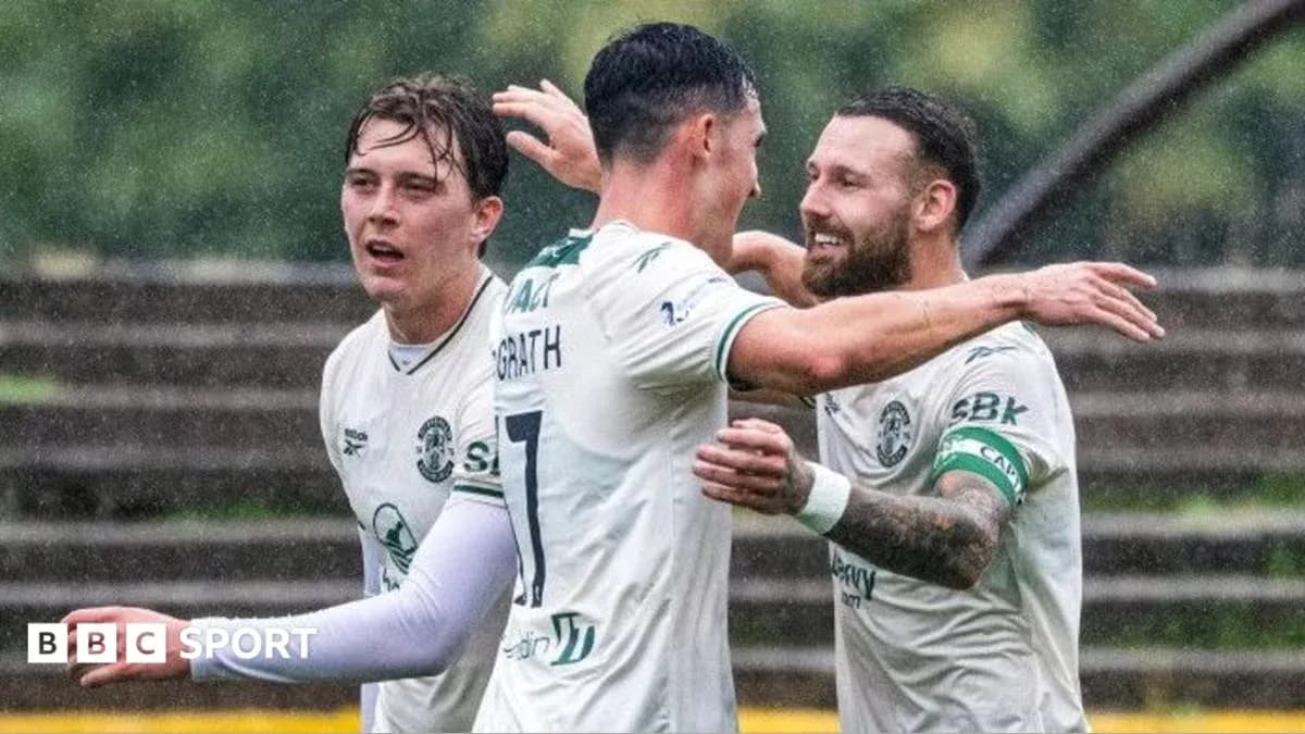 Players celebrating a goal in rainy conditions Players celebrating a goal in rainy conditions