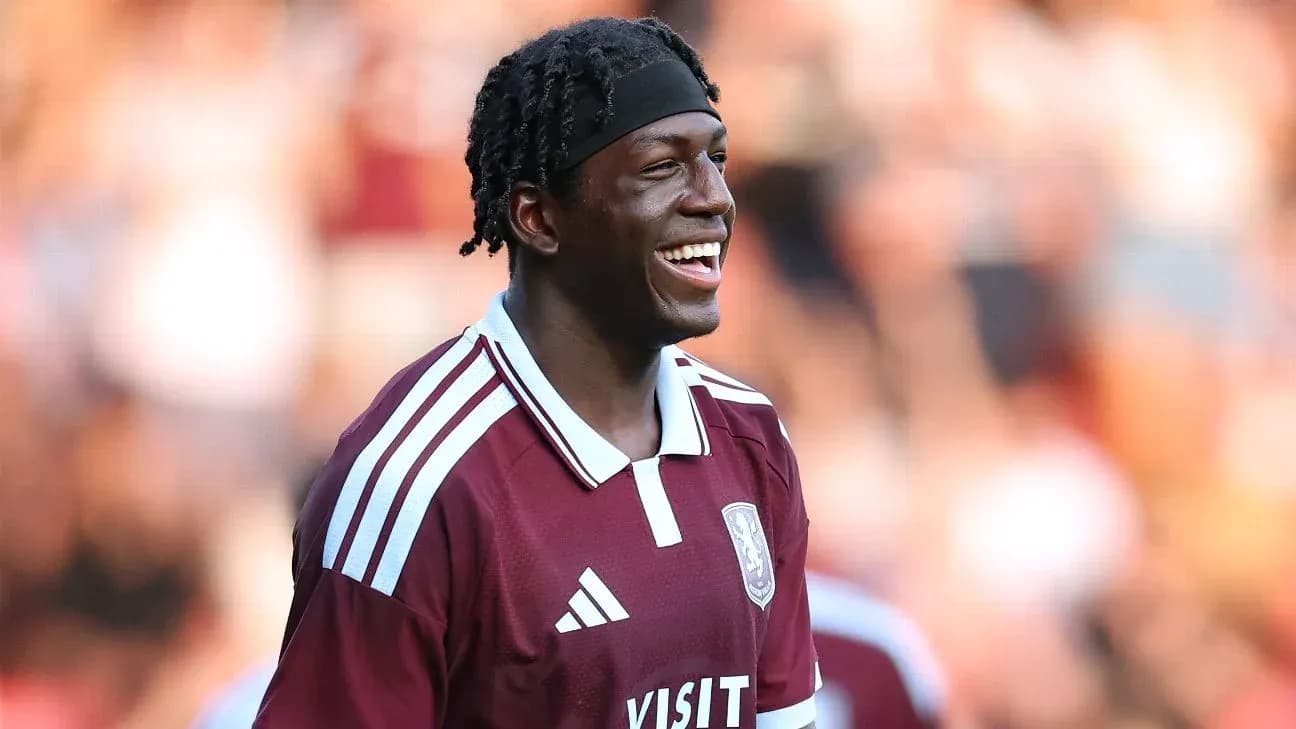 Player smiling in maroon team jersey on field Player smiling in maroon team jersey on field