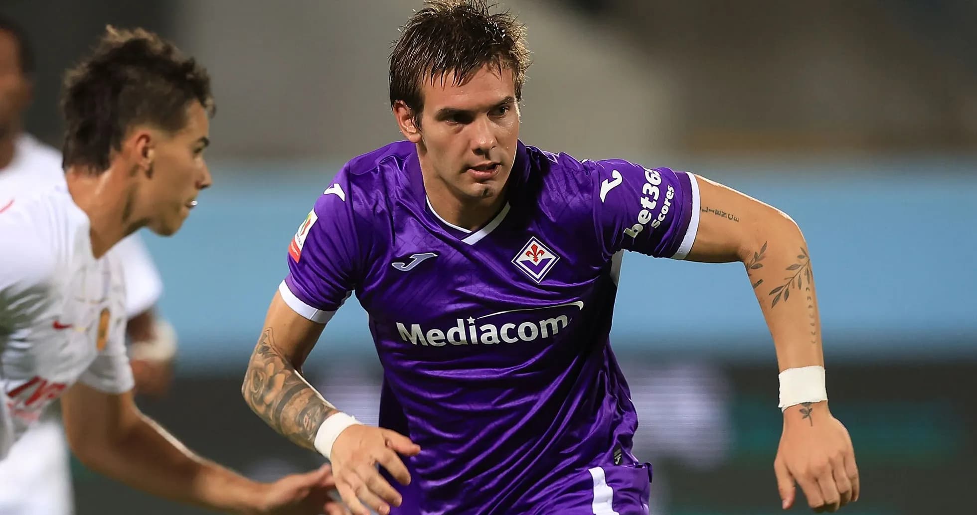 Player in purple jersey running during match Player in purple jersey running during match