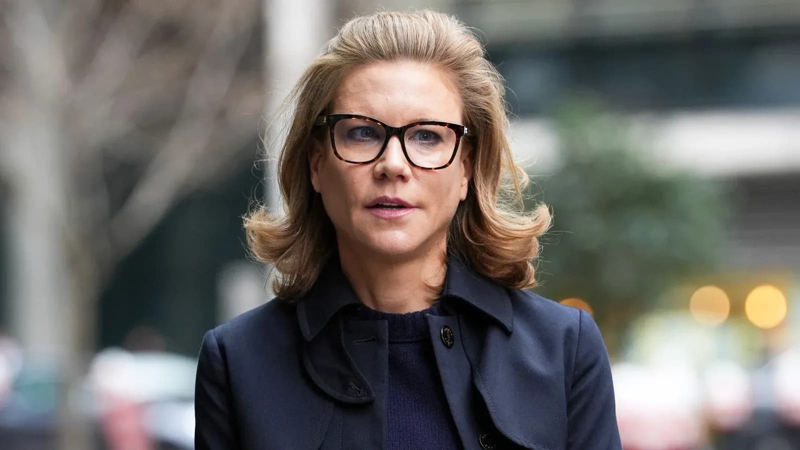 Woman with glasses walking outdoors in a coat Woman with glasses walking outdoors in a coat