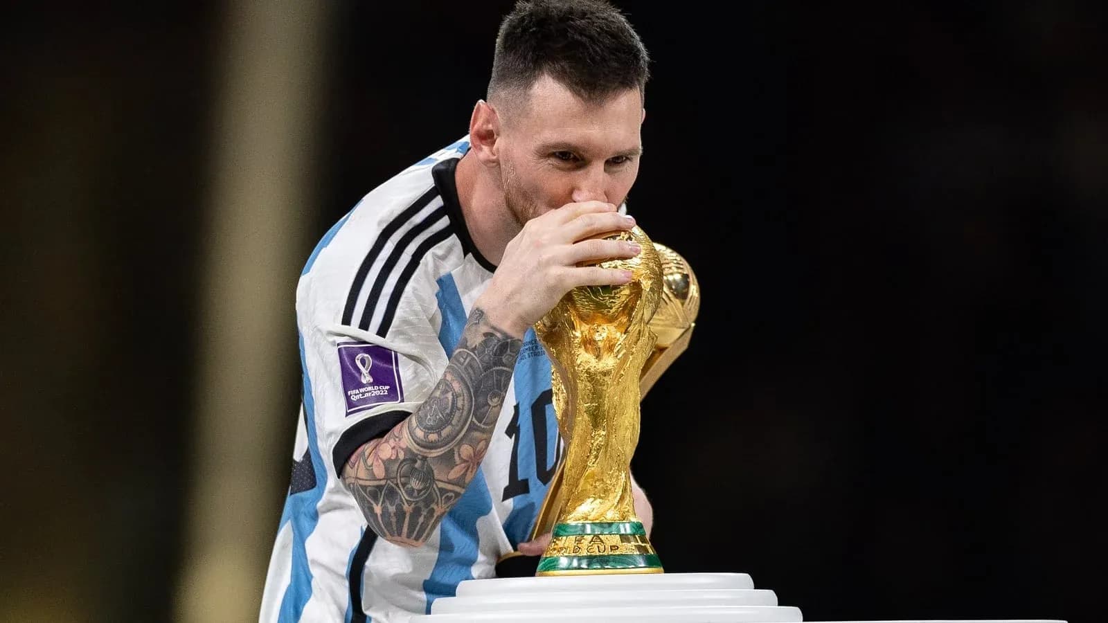 Player kissing FIFA World Cup trophy on stage Player kissing FIFA World Cup trophy on stage