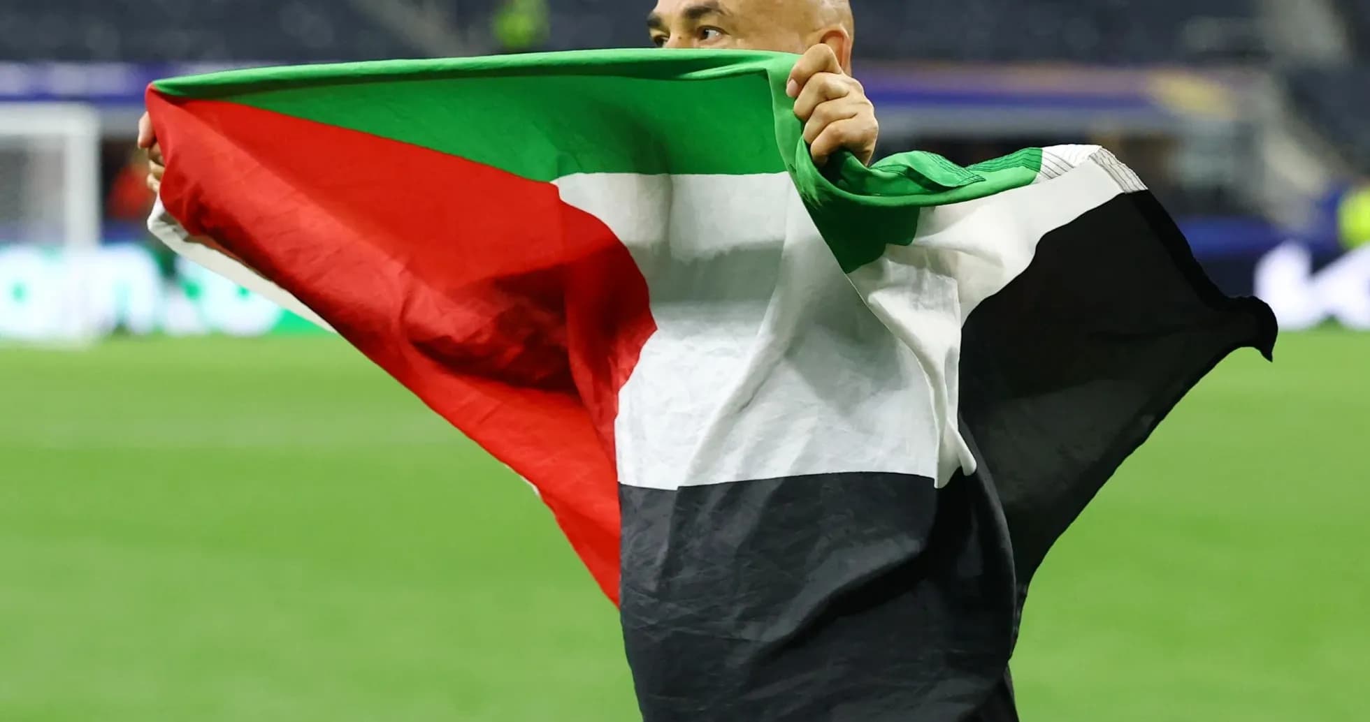 Person holding Palestinian flag on the field Person holding Palestinian flag on the field