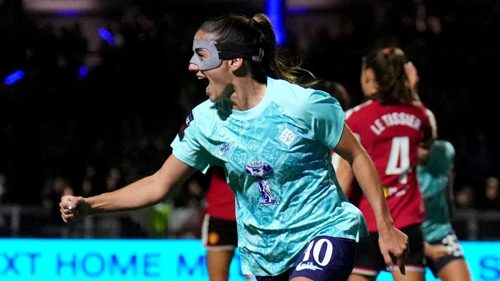 Player celebrating a goal wearing a mask Player celebrating a goal wearing a mask