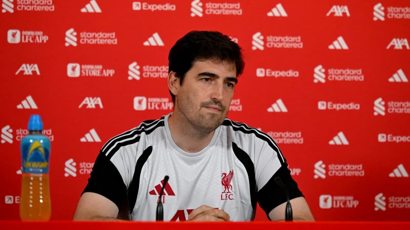Manager at press conference with Liverpool branding Manager at press conference with Liverpool branding