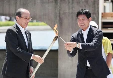 Two officials lighting a ceremonial torch together Two officials lighting a ceremonial torch together