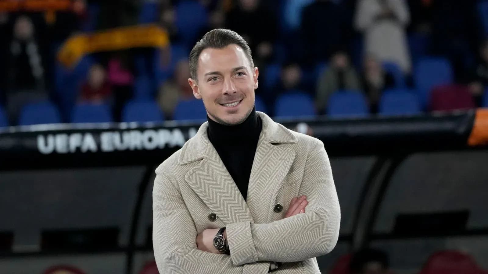 Man in stylish coat smiling at stadium Man in stylish coat smiling at stadium