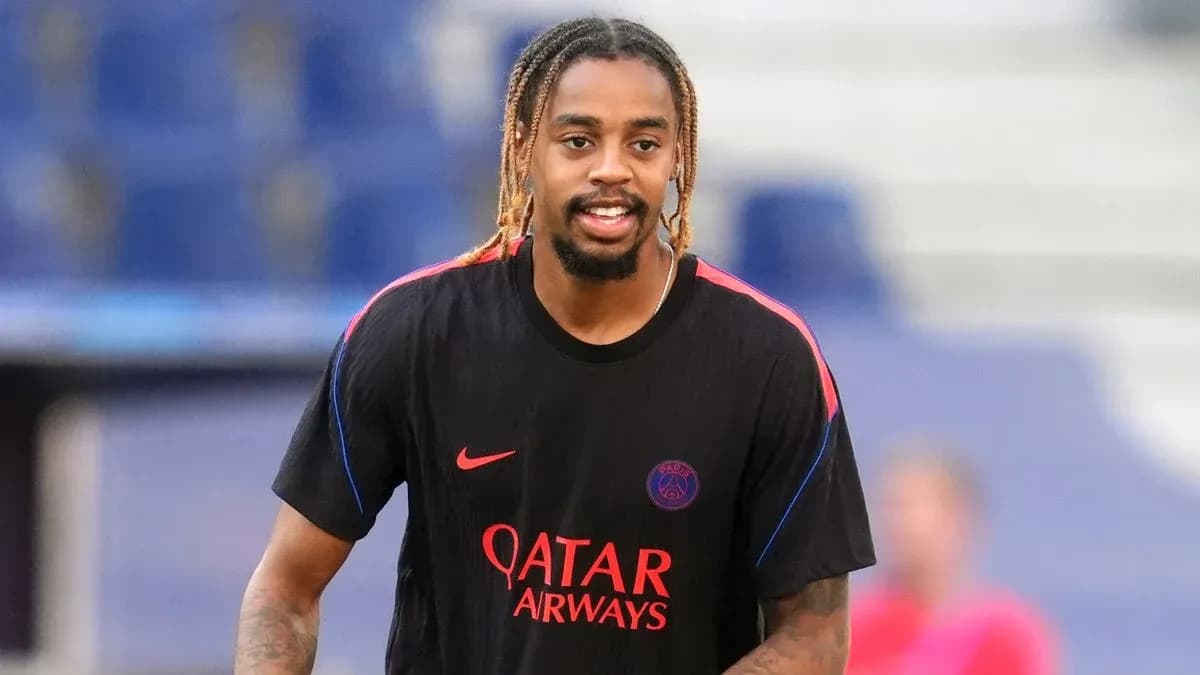 Player in PSG training kit smiling on pitch Player in PSG training kit smiling on pitch