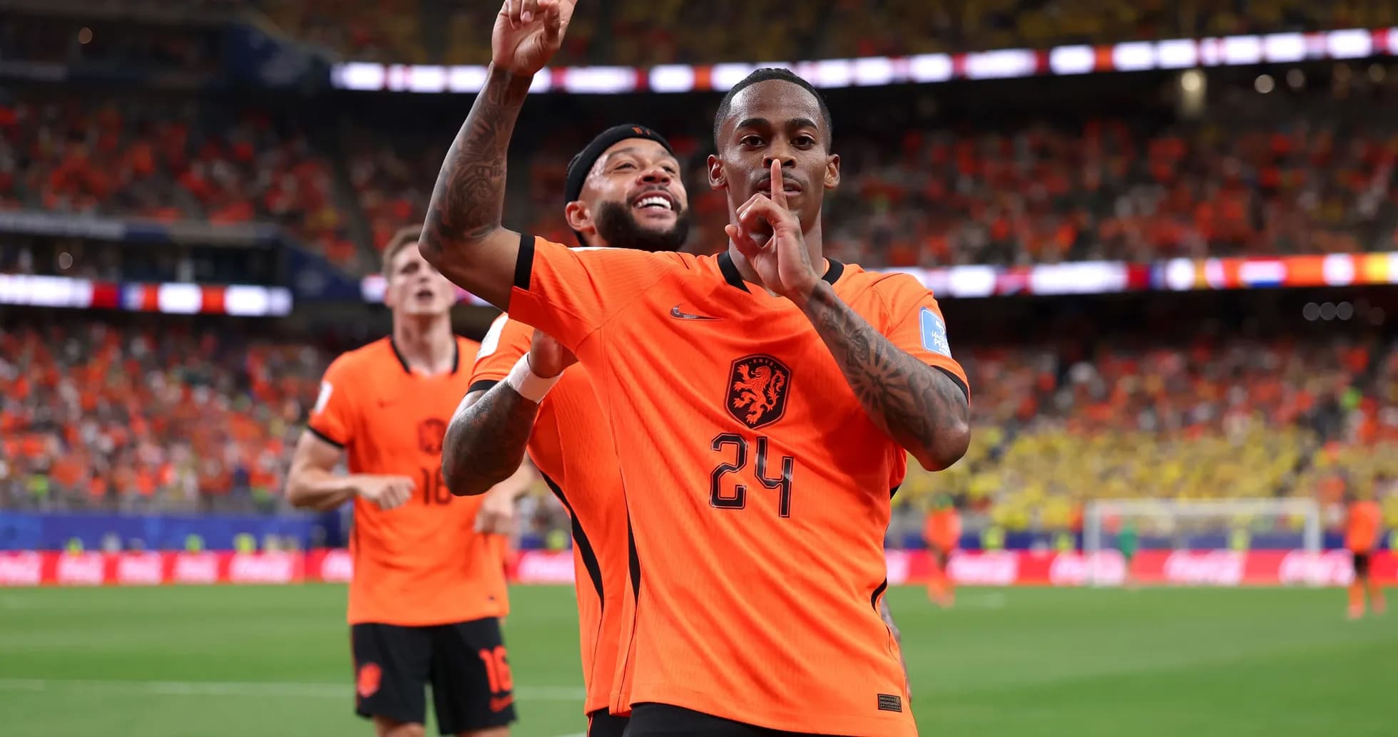 Players celebrating a goal during match in orange jerseys Players celebrating a goal during match in orange jerseys
