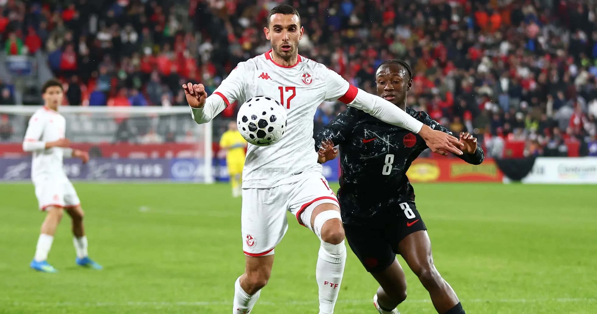 Tunisian player controls ball while being challenged Tunisian player controls ball while being challenged
