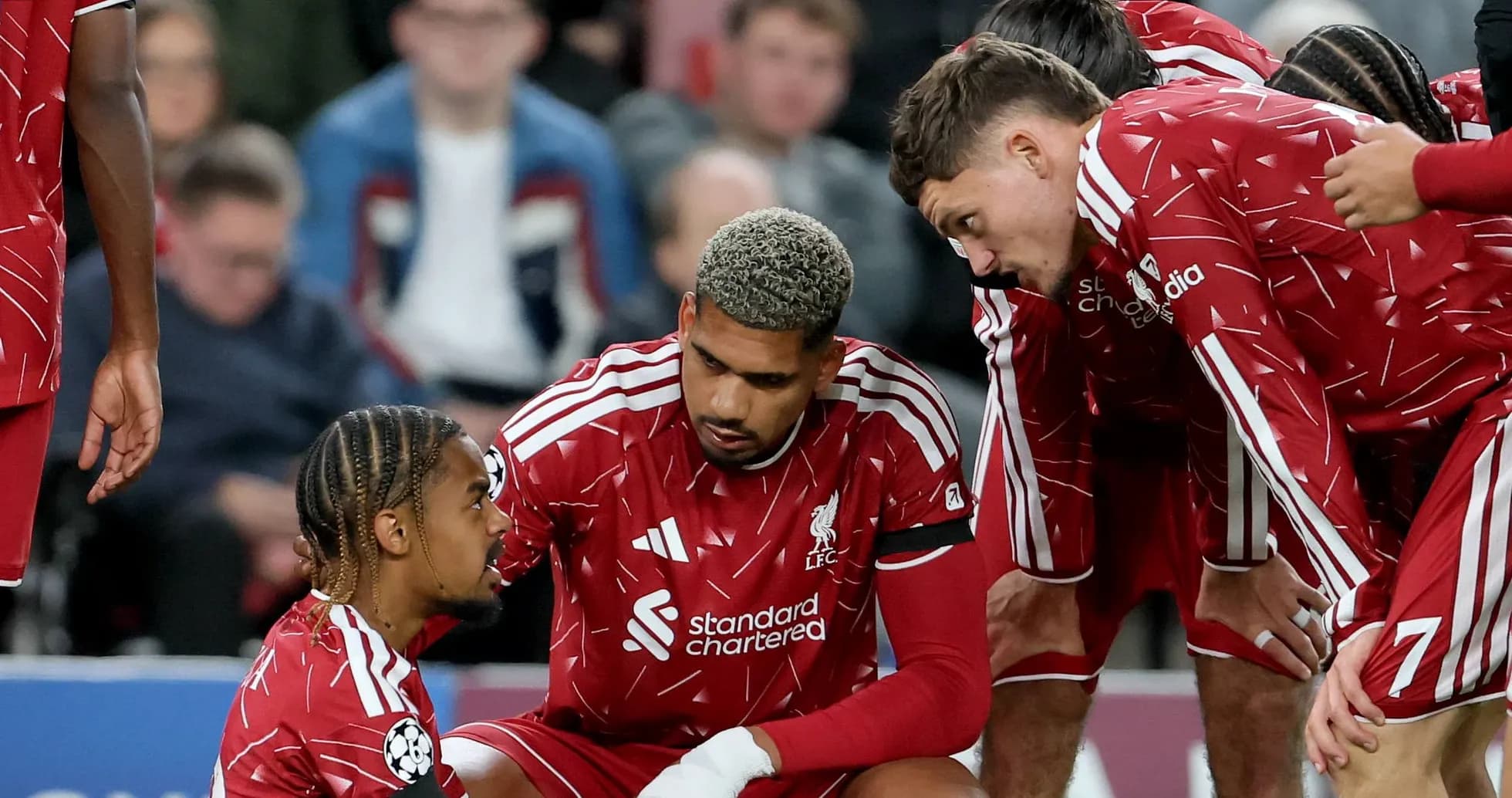 Liverpool players discussing strategy during a match Liverpool players discussing strategy during a match