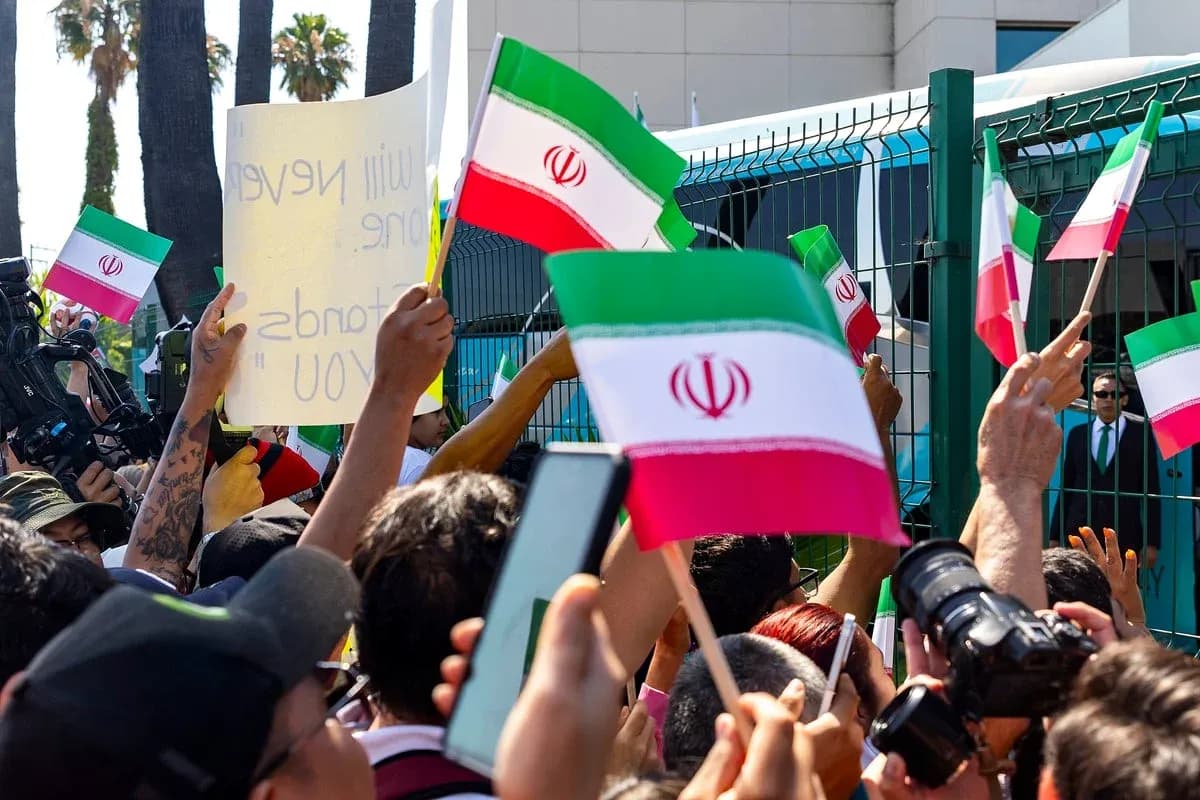 Crowd holding Iranian flags and signs at protest Crowd holding Iranian flags and signs at protest