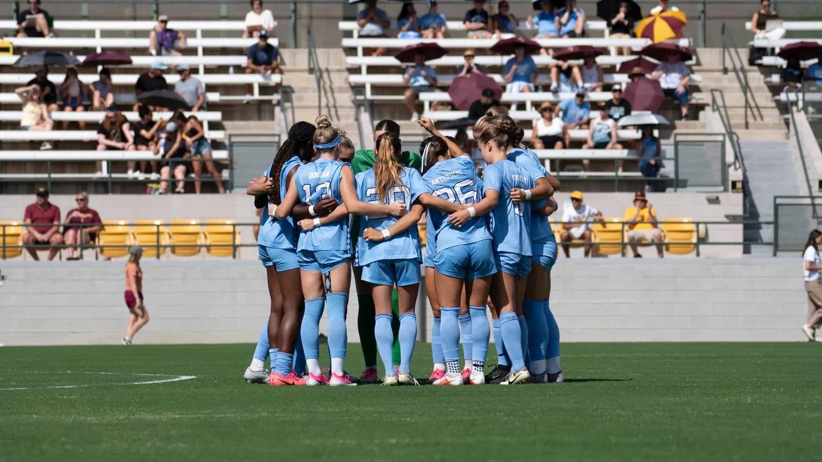 Team huddling together on the soccer field Team huddling together on the soccer field
