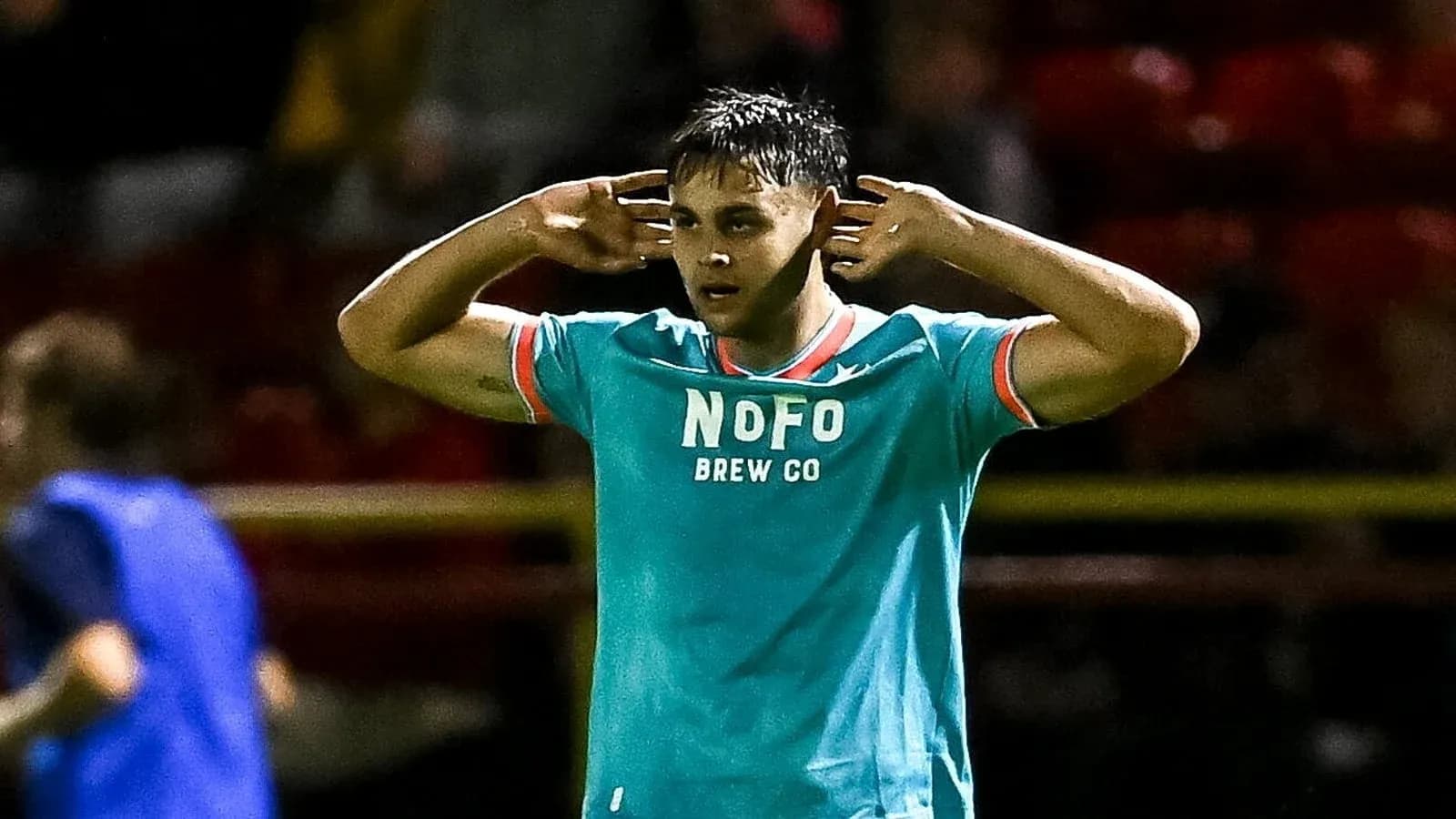 Player celebrating with hands to ears after scoring Player celebrating with hands to ears after scoring