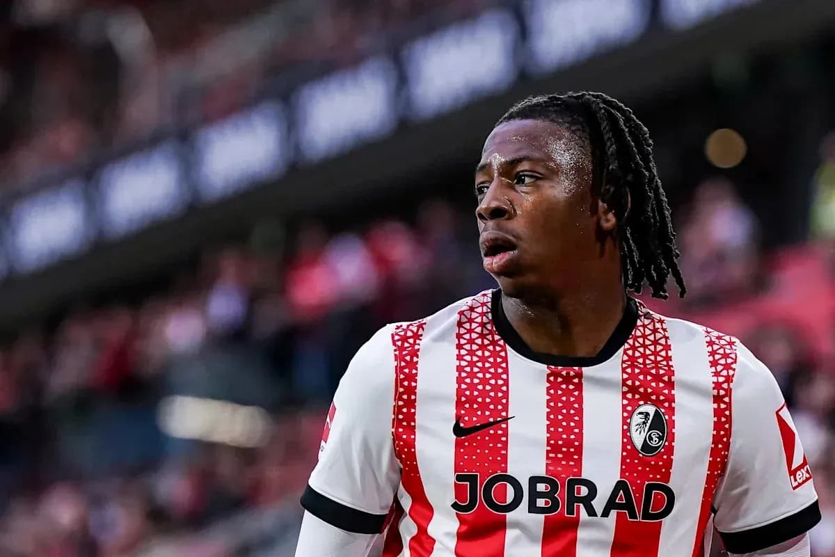 Player wearing red and white striped jersey on pitch Player wearing red and white striped jersey on pitch
