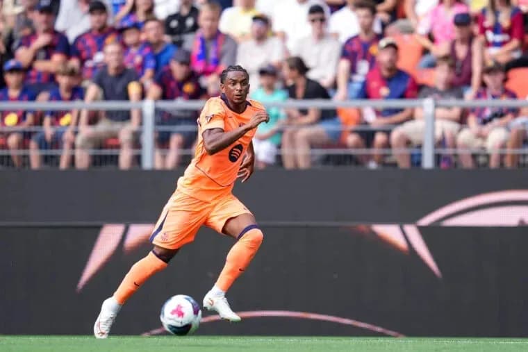 Player in orange kit running on the pitch Player in orange kit running on the pitch