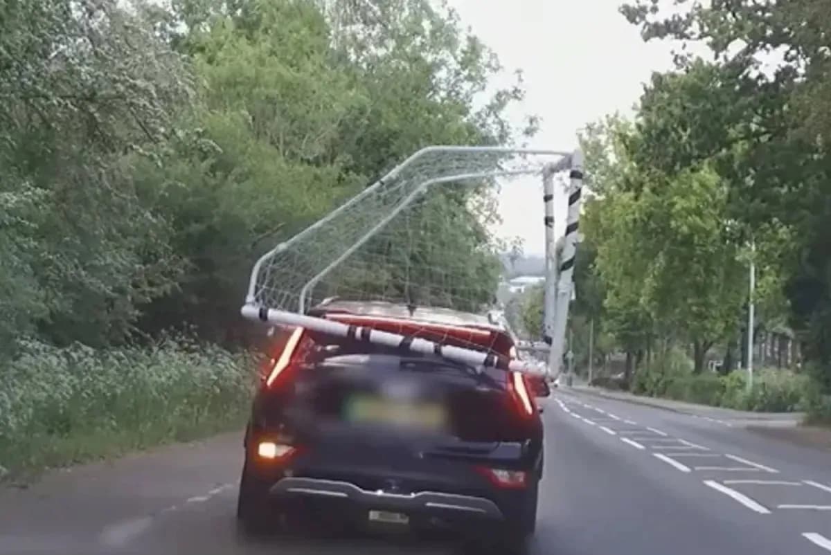 Car transporting a football goal on the road Car transporting a football goal on the road