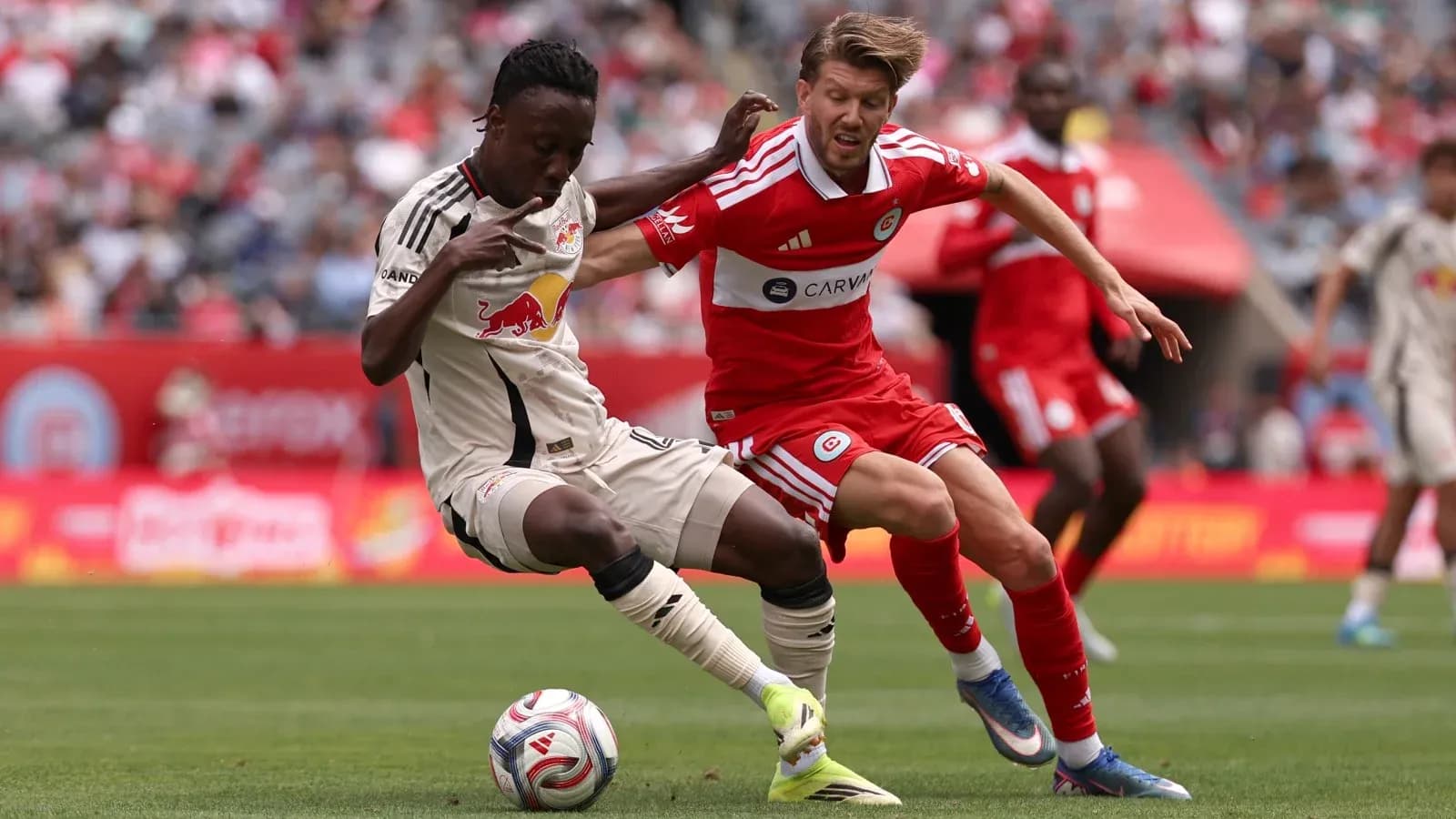 New York Red Bulls player tackling Chicago Fire opponent New York Red Bulls player tackling Chicago Fire opponent