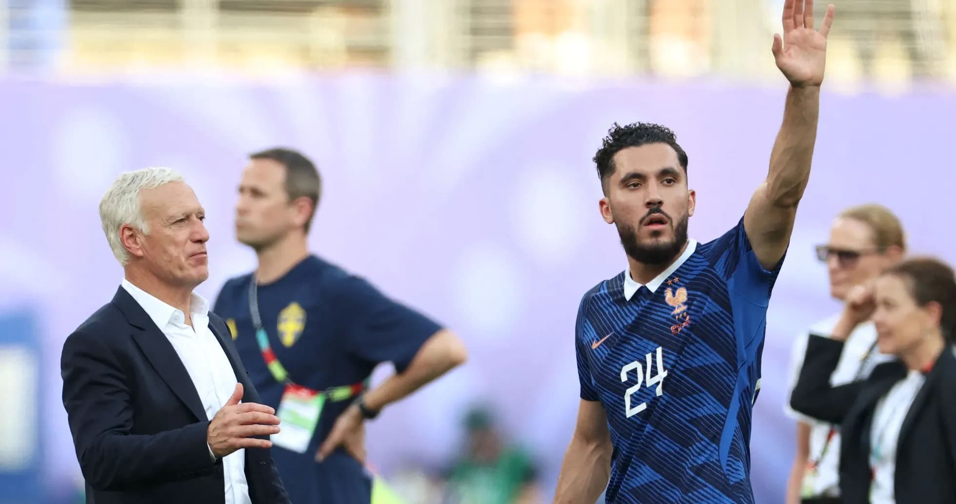 Player waving while coach looks on during match Player waving while coach looks on during match