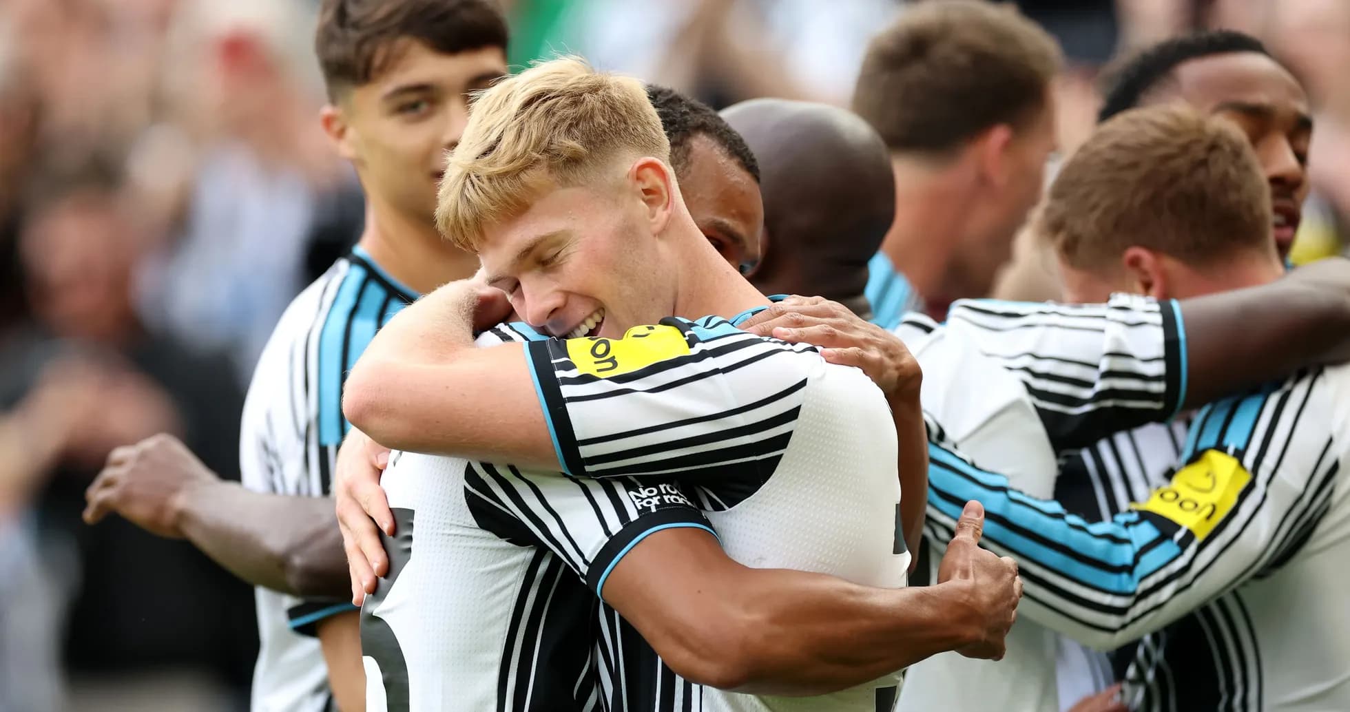 Players celebrating a goal with hugs on field Players celebrating a goal with hugs on field