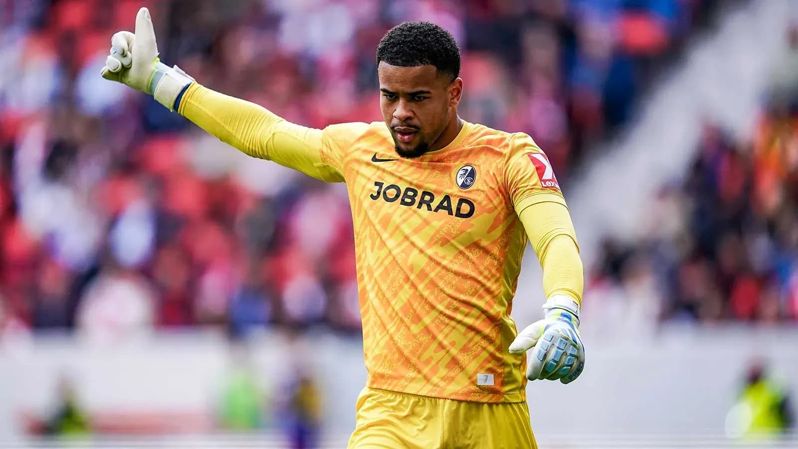 Goalkeeper in yellow jersey signaling during match Goalkeeper in yellow jersey signaling during match
