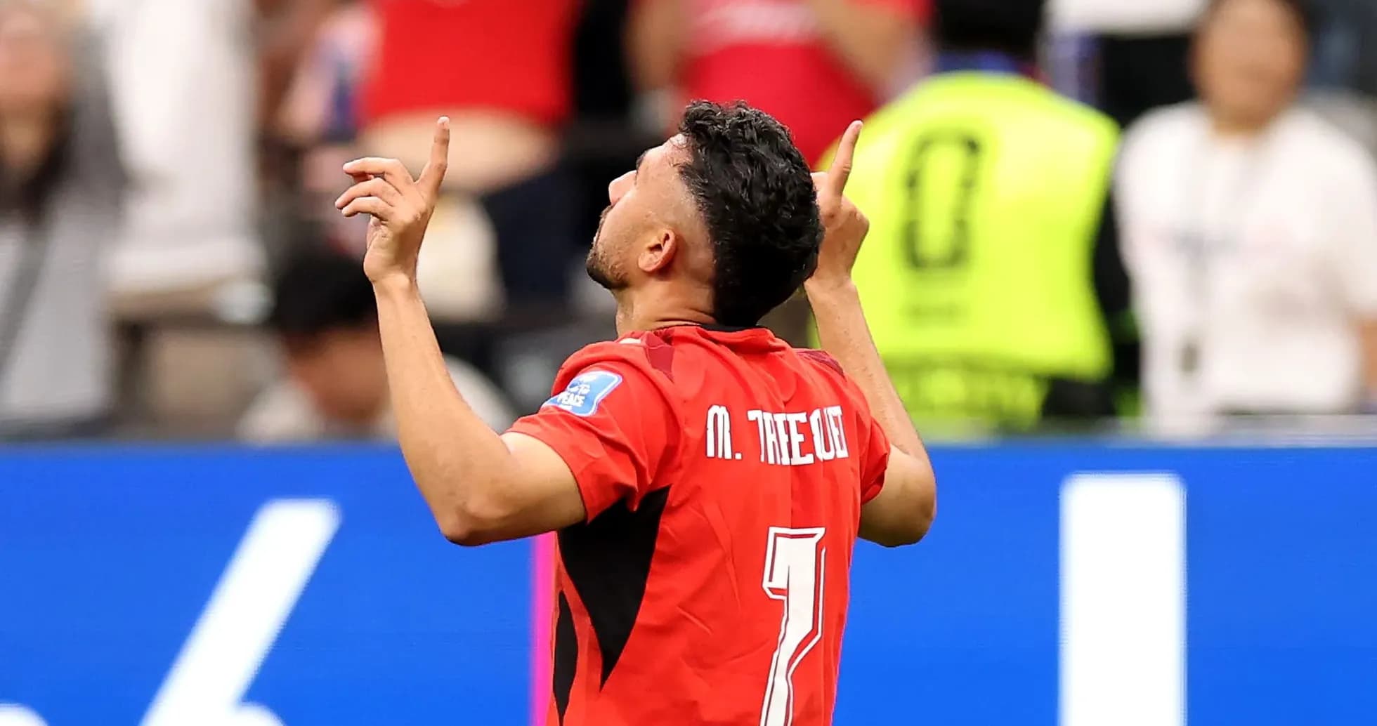 Player celebrating a goal with arms raised Player celebrating a goal with arms raised