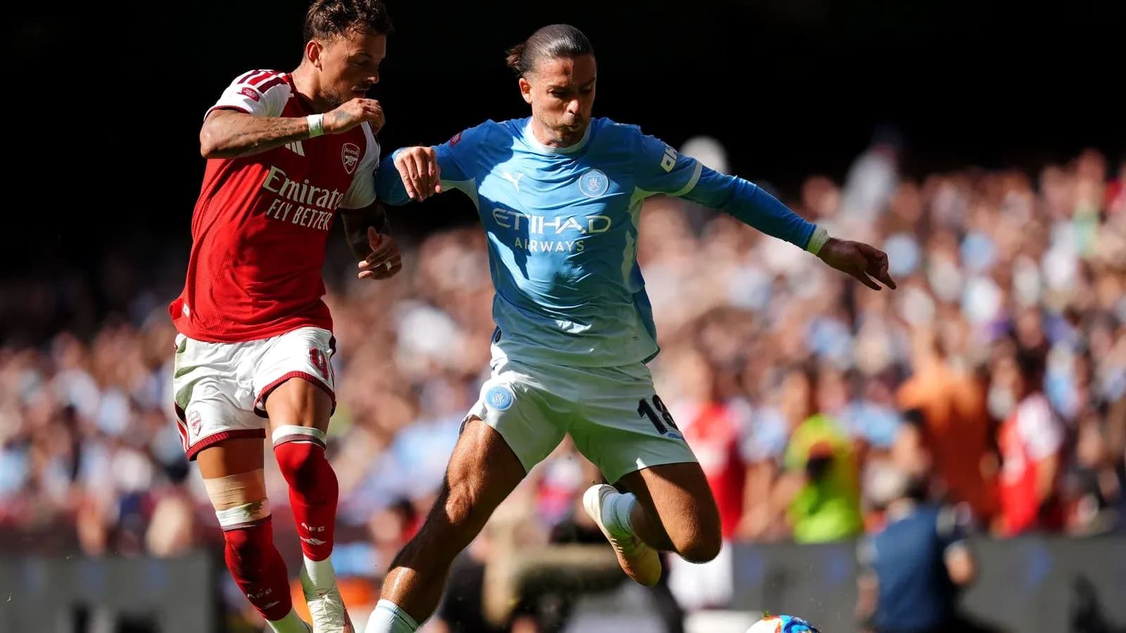 Player from Arsenal challenges Manchester City player for ball Player from Arsenal challenges Manchester City player for ball