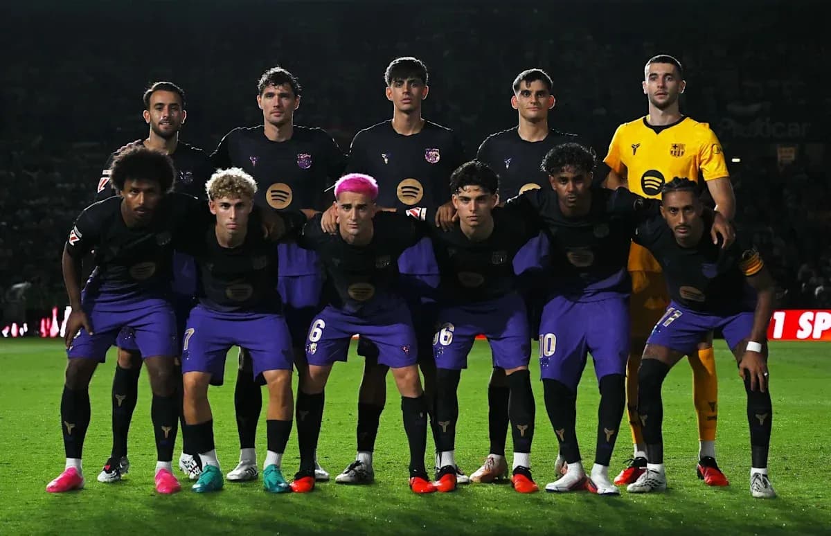 Football team posing for a group photo on field Football team posing for a group photo on field
