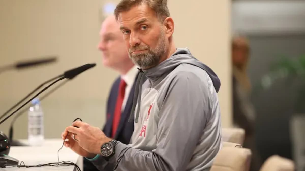 Manager sitting at press conference table with microphone Manager sitting at press conference table with microphone