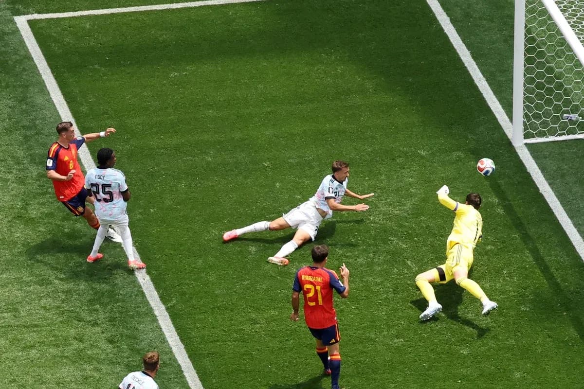 Player shooting on goal as goalkeeper dives to save Player shooting on goal as goalkeeper dives to save