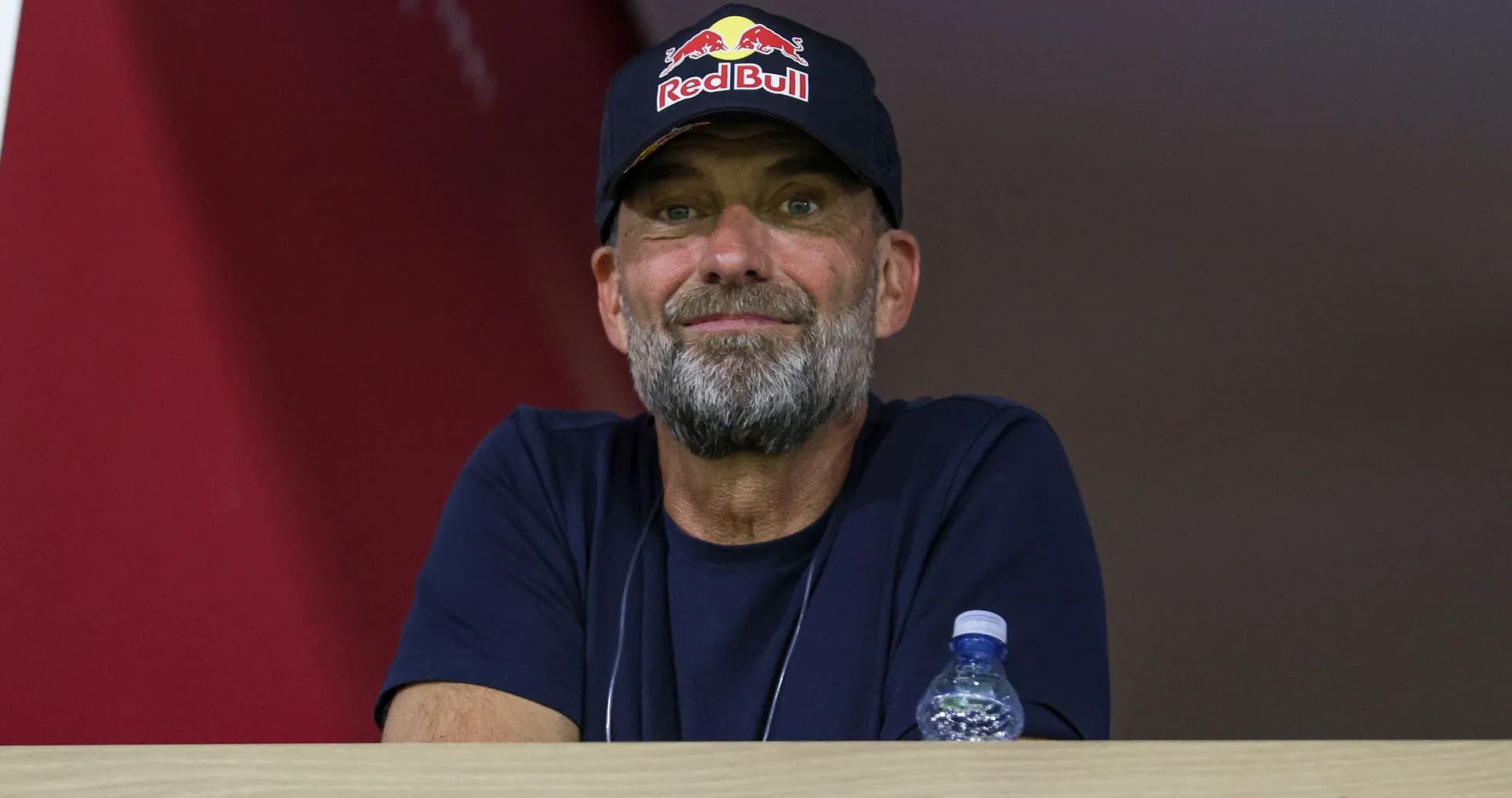 Man with beard wearing Red Bull cap in stands Man with beard wearing Red Bull cap in stands