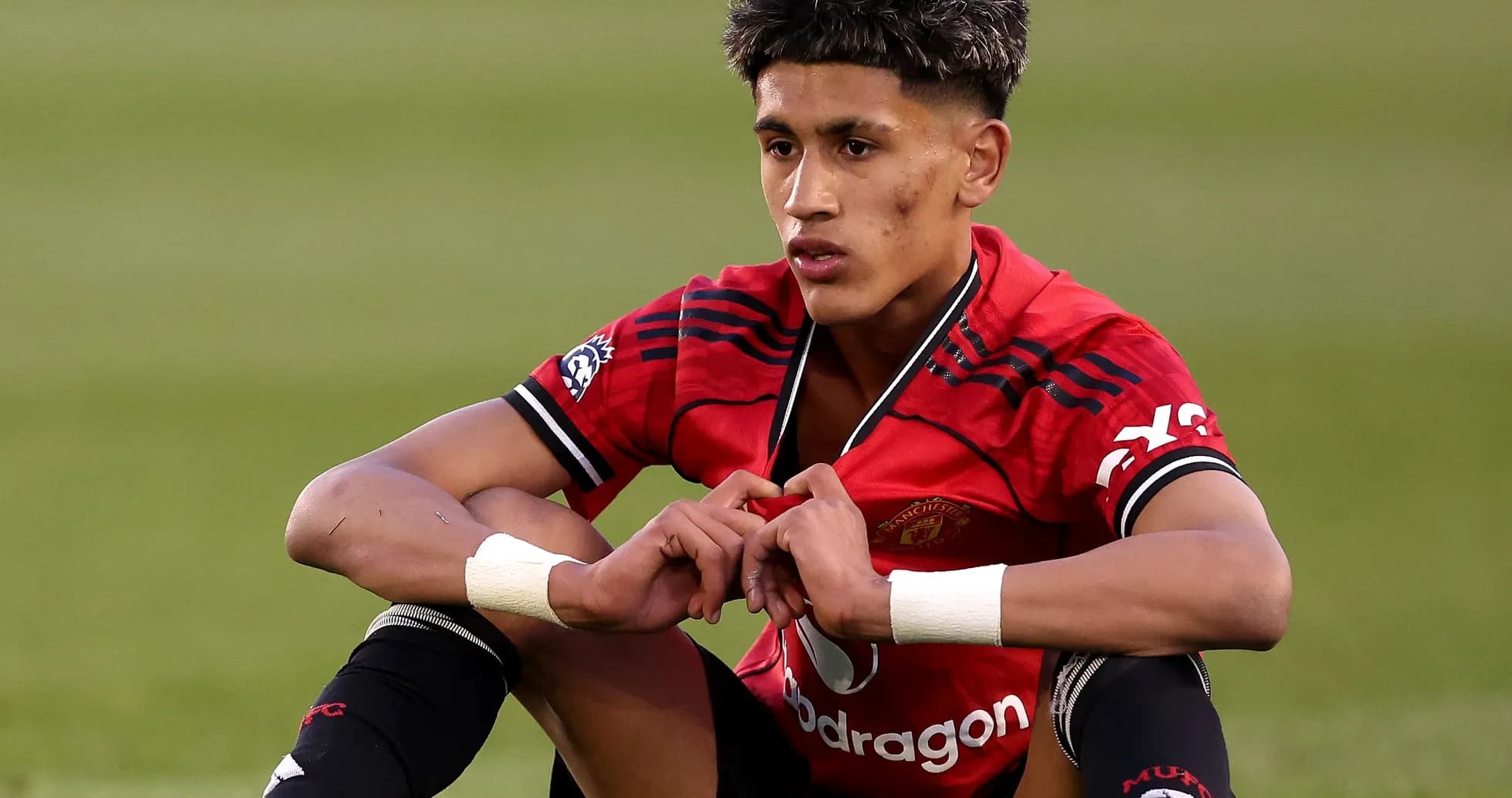 Player sitting on field in Manchester United kit Player sitting on field in Manchester United kit