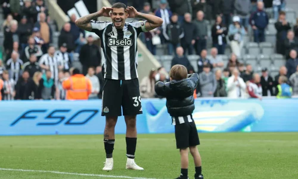 Newcastle player celebrating with child on pitch Newcastle player celebrating with child on pitch