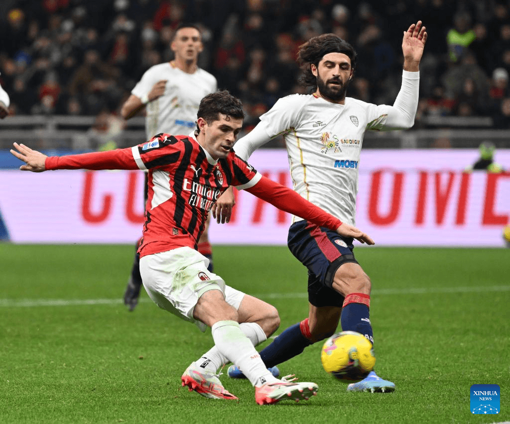 AC Milan player challenges Cagliari opponent for the ball AC Milan player challenges Cagliari opponent for the ball