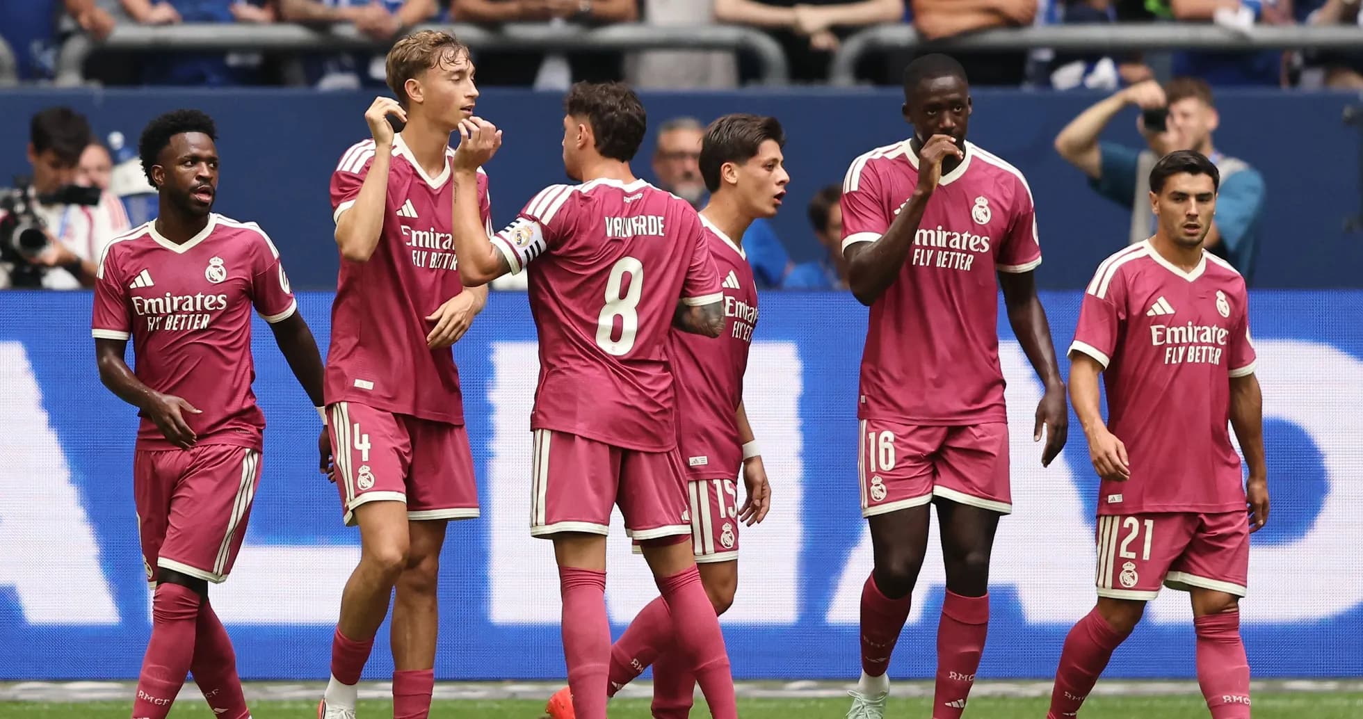 Real Madrid players celebrating a goal on the pitch Real Madrid players celebrating a goal on the pitch