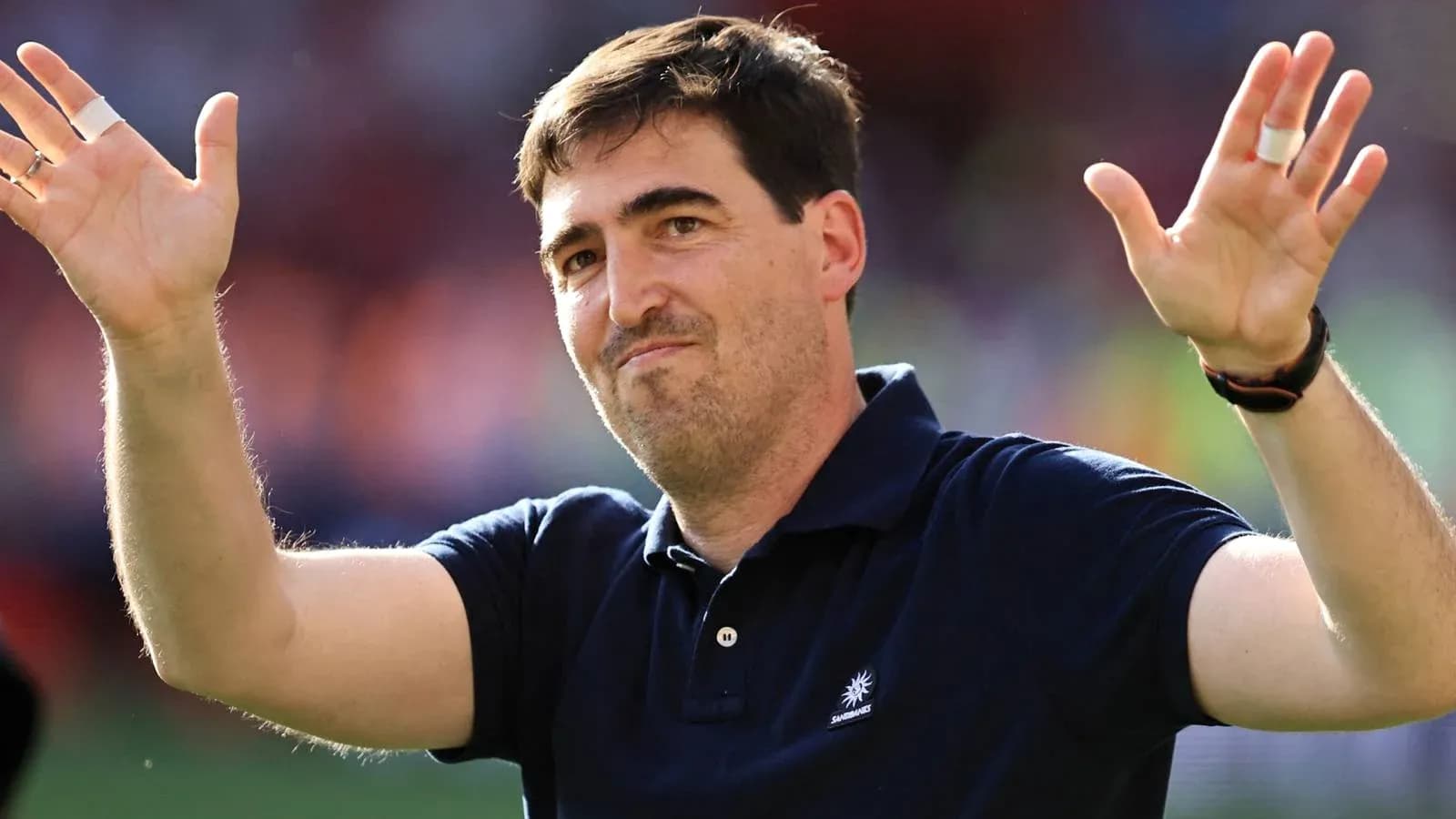 Coach gesturing to fans after match conclusion Coach gesturing to fans after match conclusion