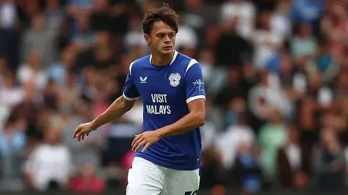 Player in blue jersey running on the pitch Player in blue jersey running on the pitch