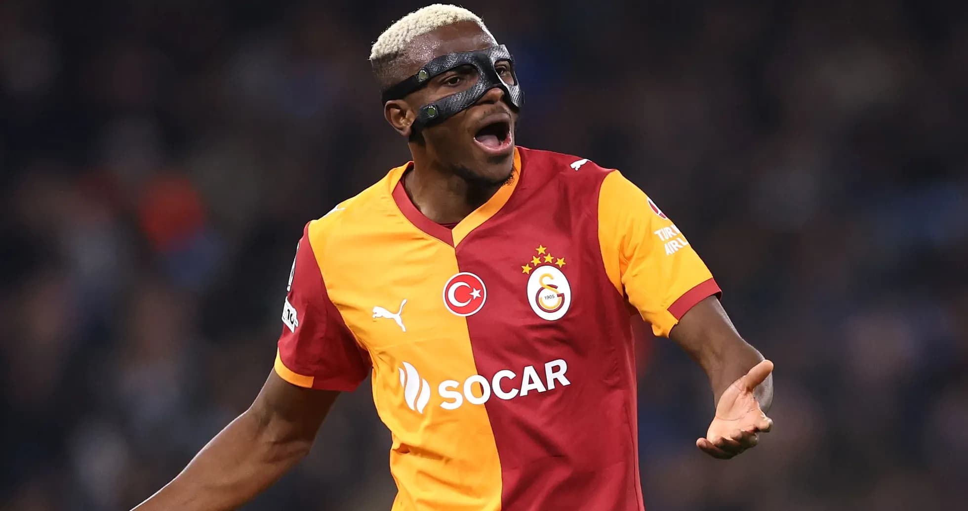 Player celebrating wearing a protective mask during match Player celebrating wearing a protective mask during match