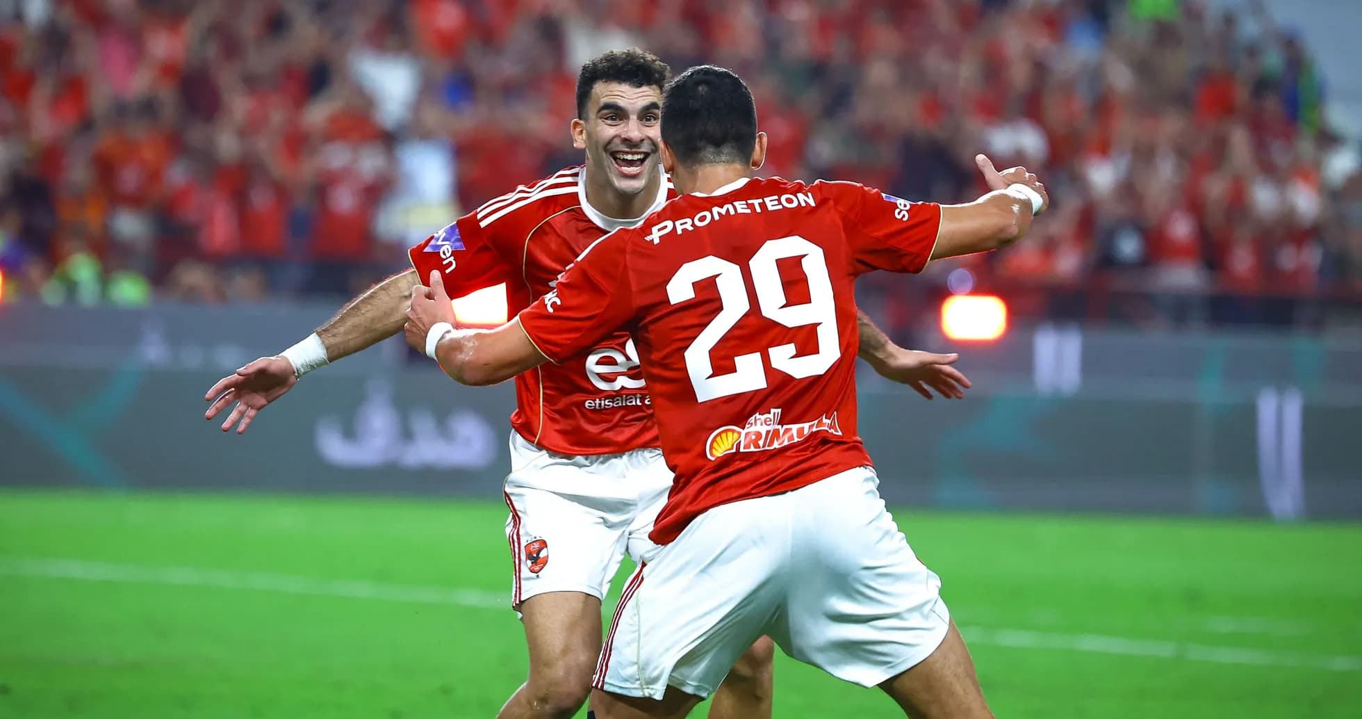 Two players celebrating a goal on the field Two players celebrating a goal on the field